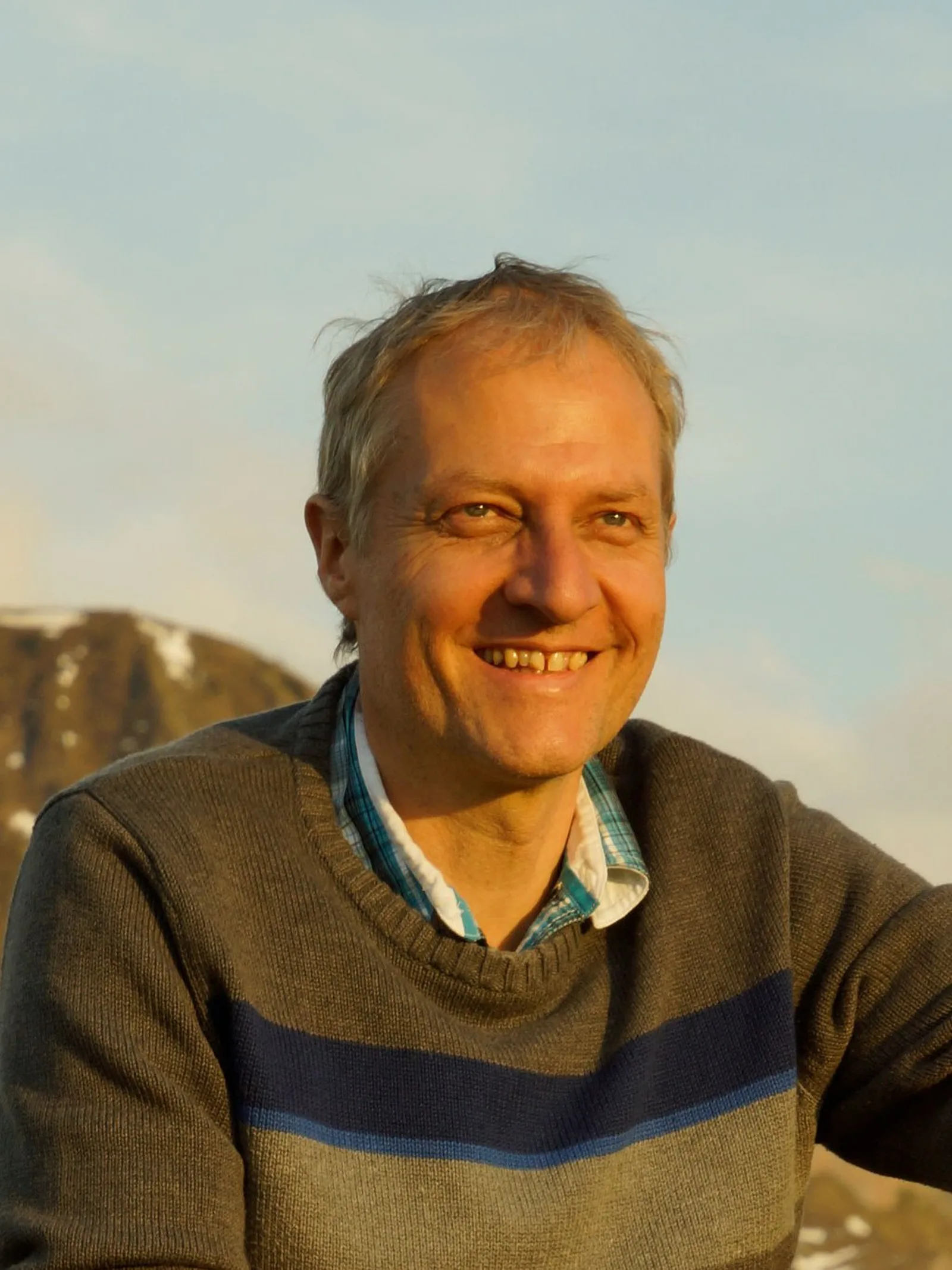 Peter, Kursleiter in der Buitig, im Pullover vor abendlichem Himmel