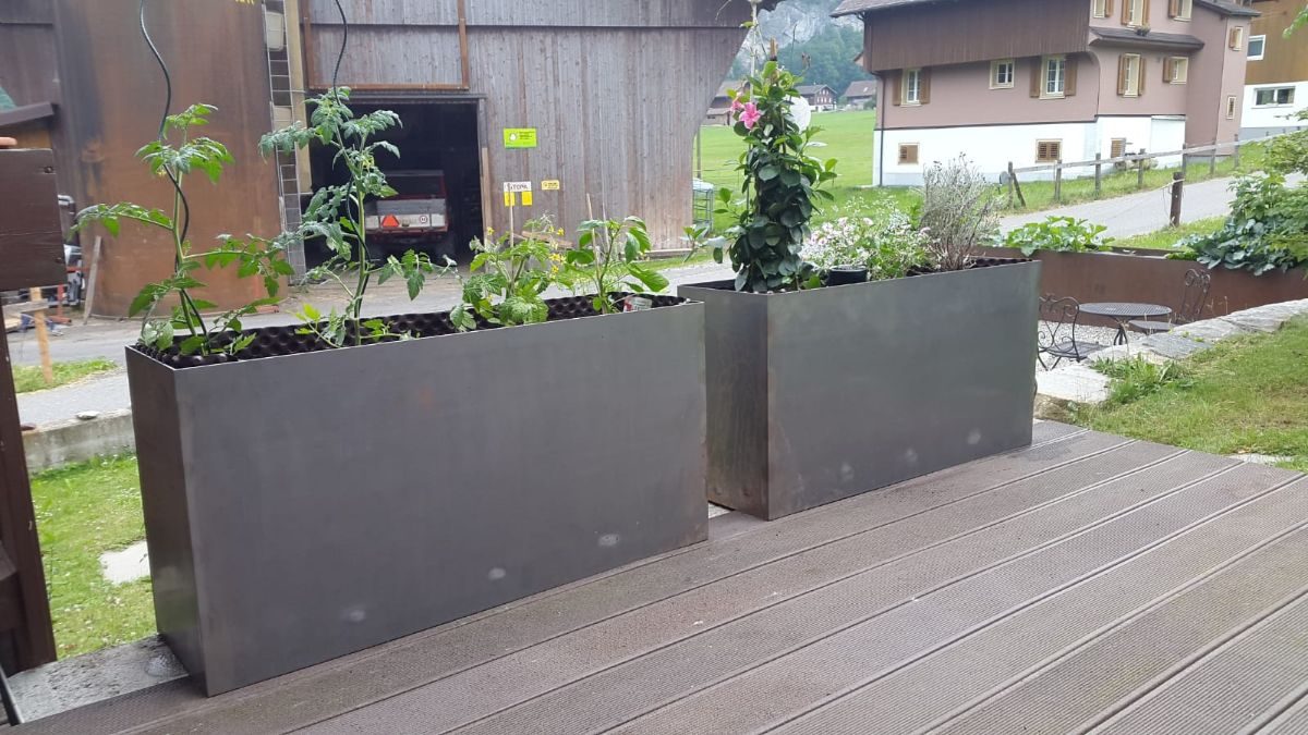 Langer bepflanzter Pflanztrog aus Rohstahl entlang einer Terrasse